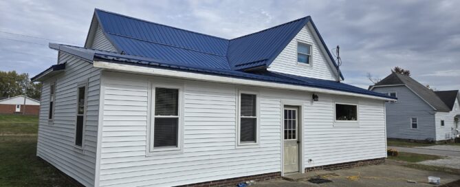 crisp white vinyl siding paired with a royal blue metal roof installation in greater indianapolis