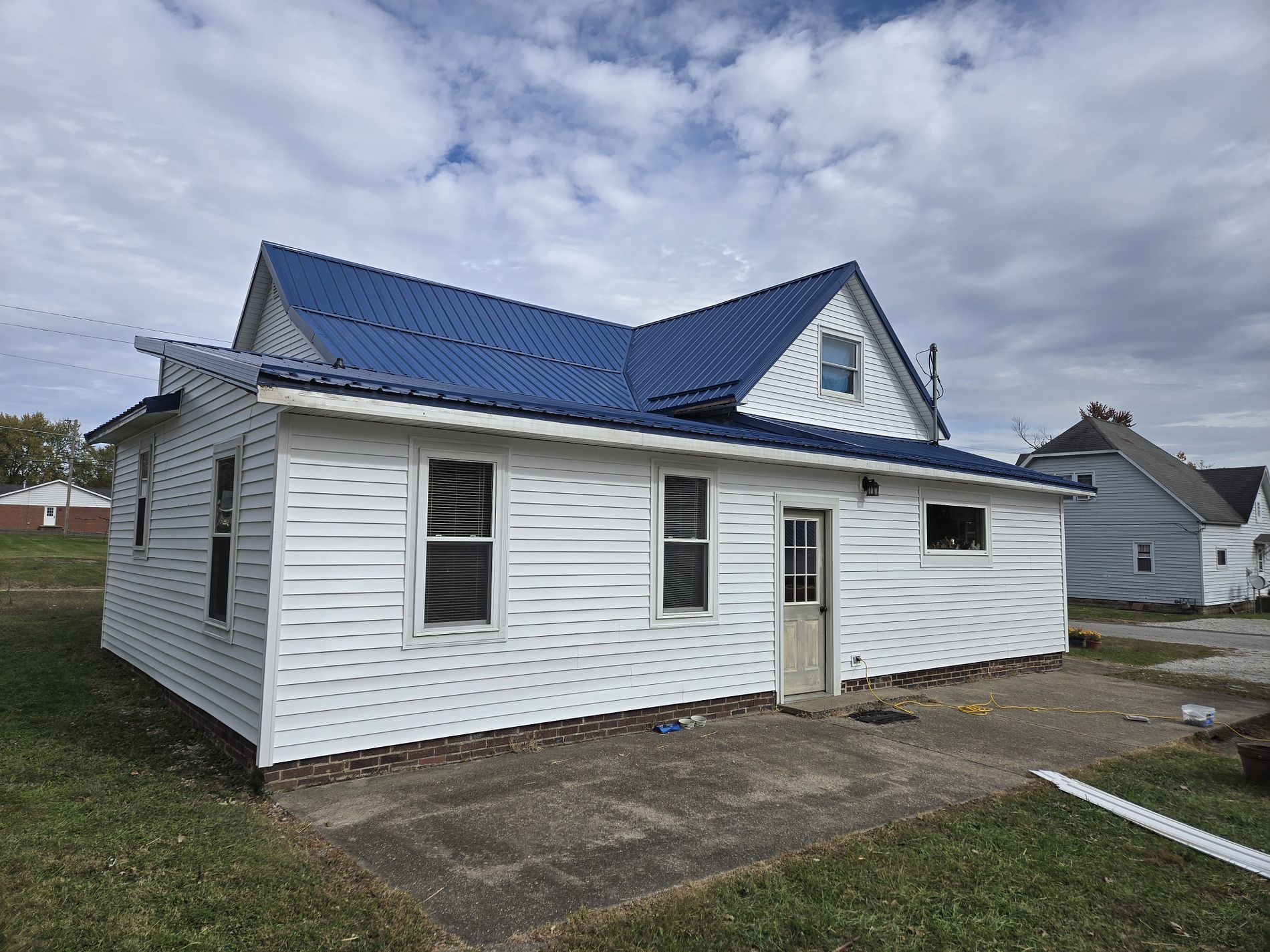 crisp white vinyl siding paired with a royal blue metal roof installation in greater indianapolis
